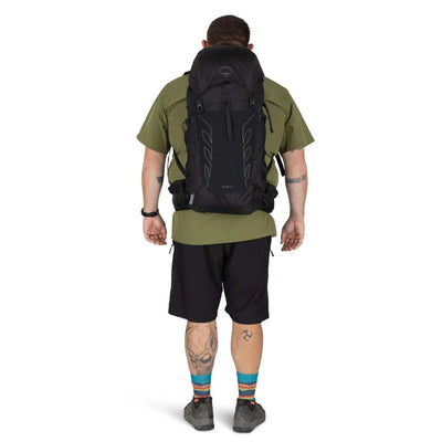 Men's Osprey Talon 33 Extended Fit travel daypack with hiking poles attached to the side.