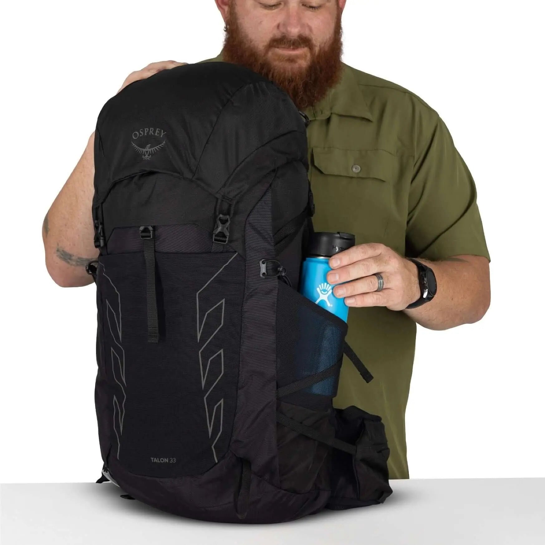 Man with Osprey Talon 33 Extended Fit men's travel daypack, showing bottle pocket
