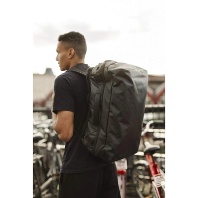 Man wearing the Transporter Squffel 44 backpack, designed for adventure and rugged use.