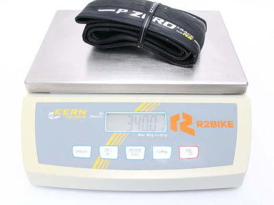 Pirelli P Zero Race RS Tubeless Ready Tire on digital scale demonstrating lightweight for high-performance cycling.