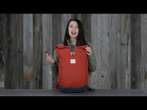 Woman holding Osprey Arcane Roll Top backpack, featuring durable recycled fabric and modern design for everyday use.