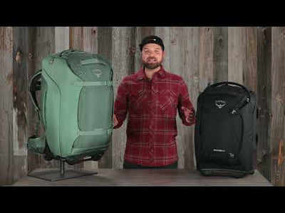 Man displaying Osprey Sojourn Shuttle Wheeled Duffel 25"/60L in green and black, highlighting features like HighRoad chassis and AirScape back panel.