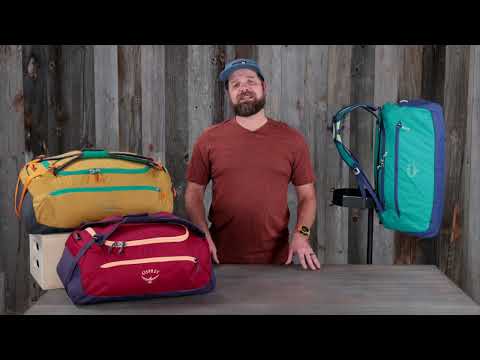 Osprey Transporter Duffel 120 displayed on a table, showing rugged weather-resistant design and stowaway harness for travel.