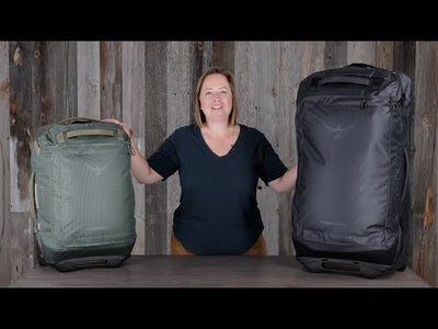 Transporter Wheeled Duffel 120 by Osprey, woman showcasing two sizes of rugged wheeled duffels.