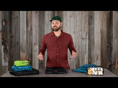 Ultralight Raincover demonstration by brand vendor showcasing various sizes on a wooden table, perfect for outdoor activities.