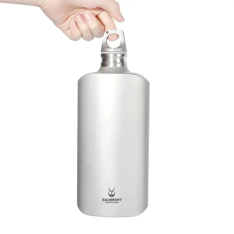 Hand holding SilverAnt Ultralight Titanium Water Bottle Slim - 27 oz / 800 ml, showcasing its sleek and durable design.