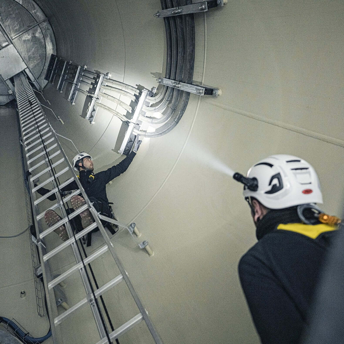 Two workers using a P5R flashlight in a tunnel, demonstrating its compact and powerful lighting capabilities.