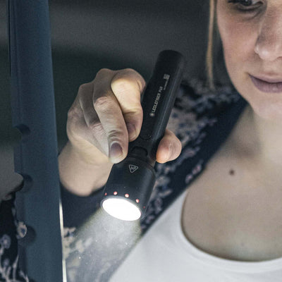 User demonstrating the P6R flashlight, showcasing its powerful beam and focusable feature.