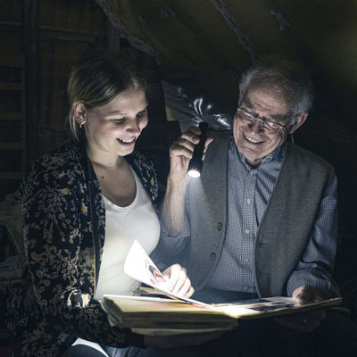 Two people enjoying a book together, illuminated by the powerful P6R flashlight.